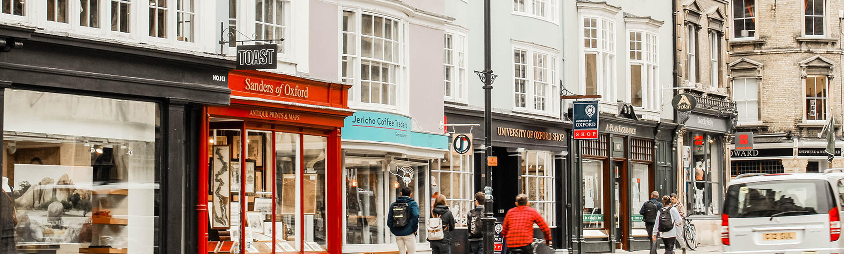 Image of Oxford city street including shops, cyclist, cars and pedestrians